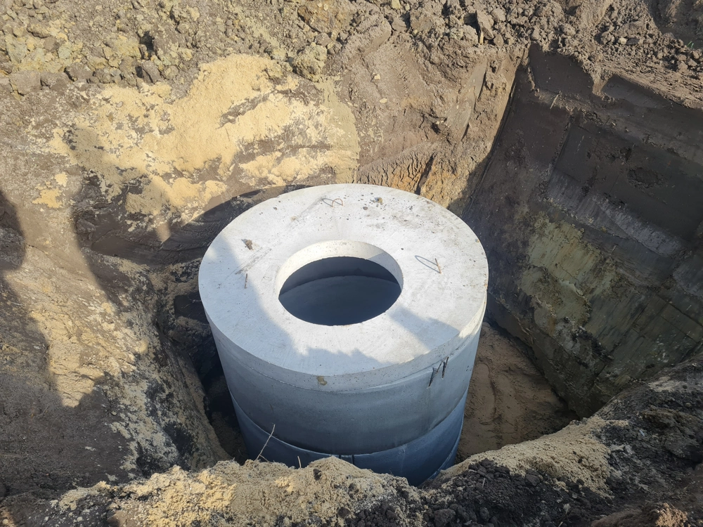 Instalacja betonowych kręgów szamba betonowego w wykopie