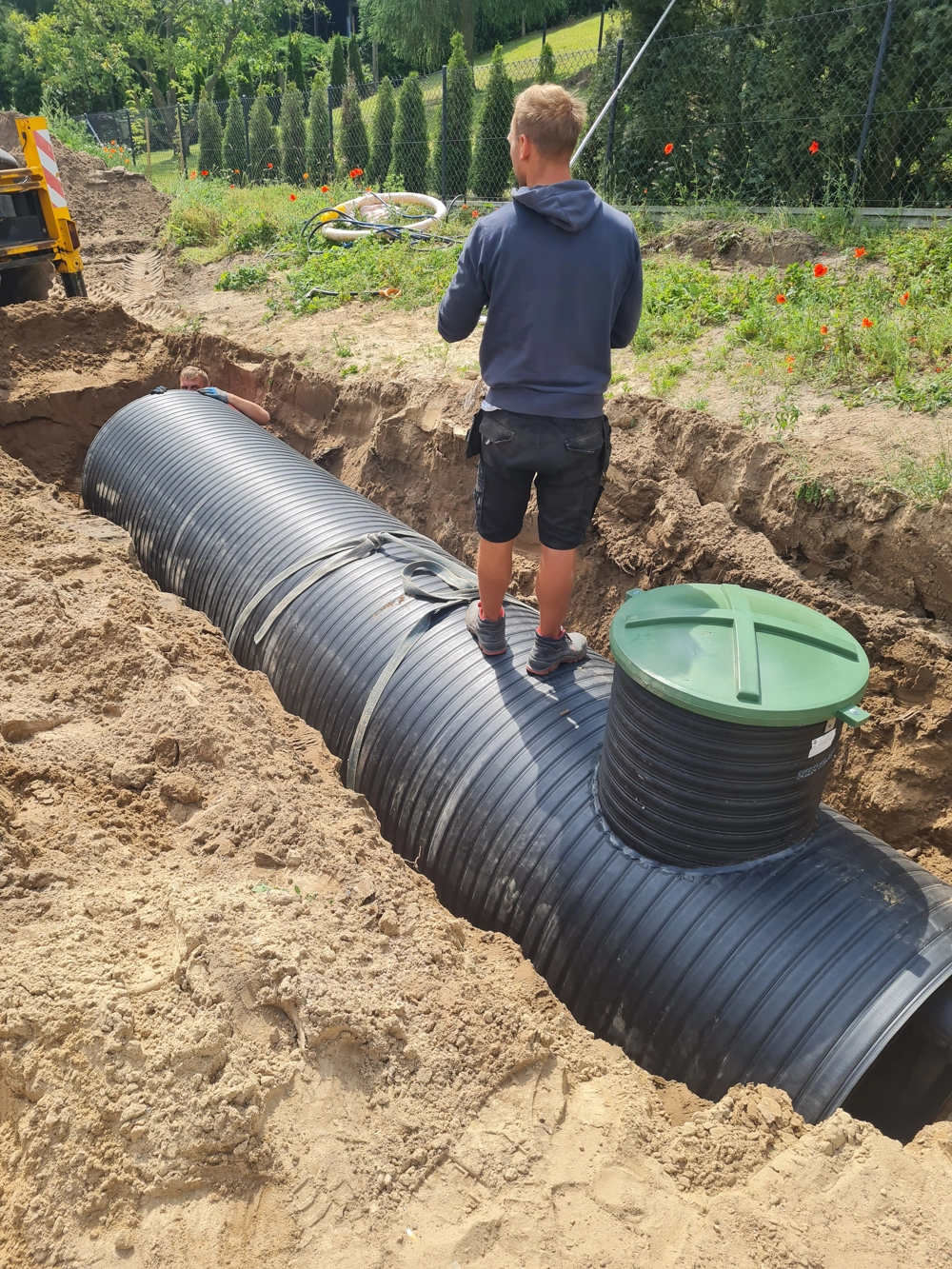 Prace ziemne przy montażu przydomowej oczyszczalni ścieków z poziomym plastikowym zbiornikiem