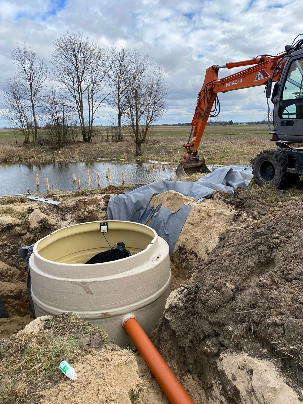 Wykop pod przydomową oczyszczalnię ścieków z osadzonym betonowym pierścieniem i rurą odpływową