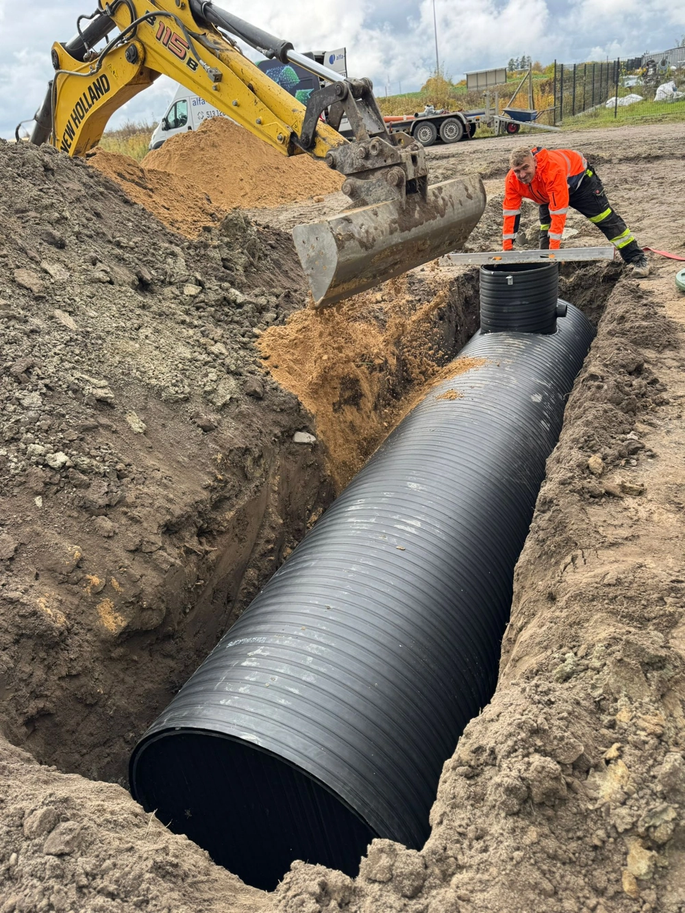 Instalacja czarnej rury karbowanej w wykopie – prace ziemne