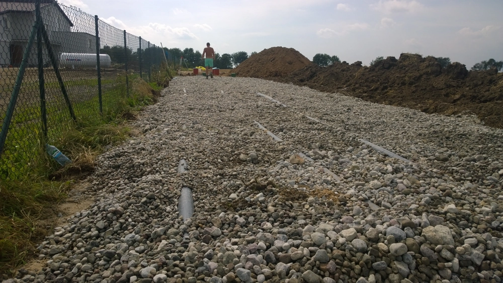 Układanie rur drenażowych na podsypce żwirowej – Drenaż